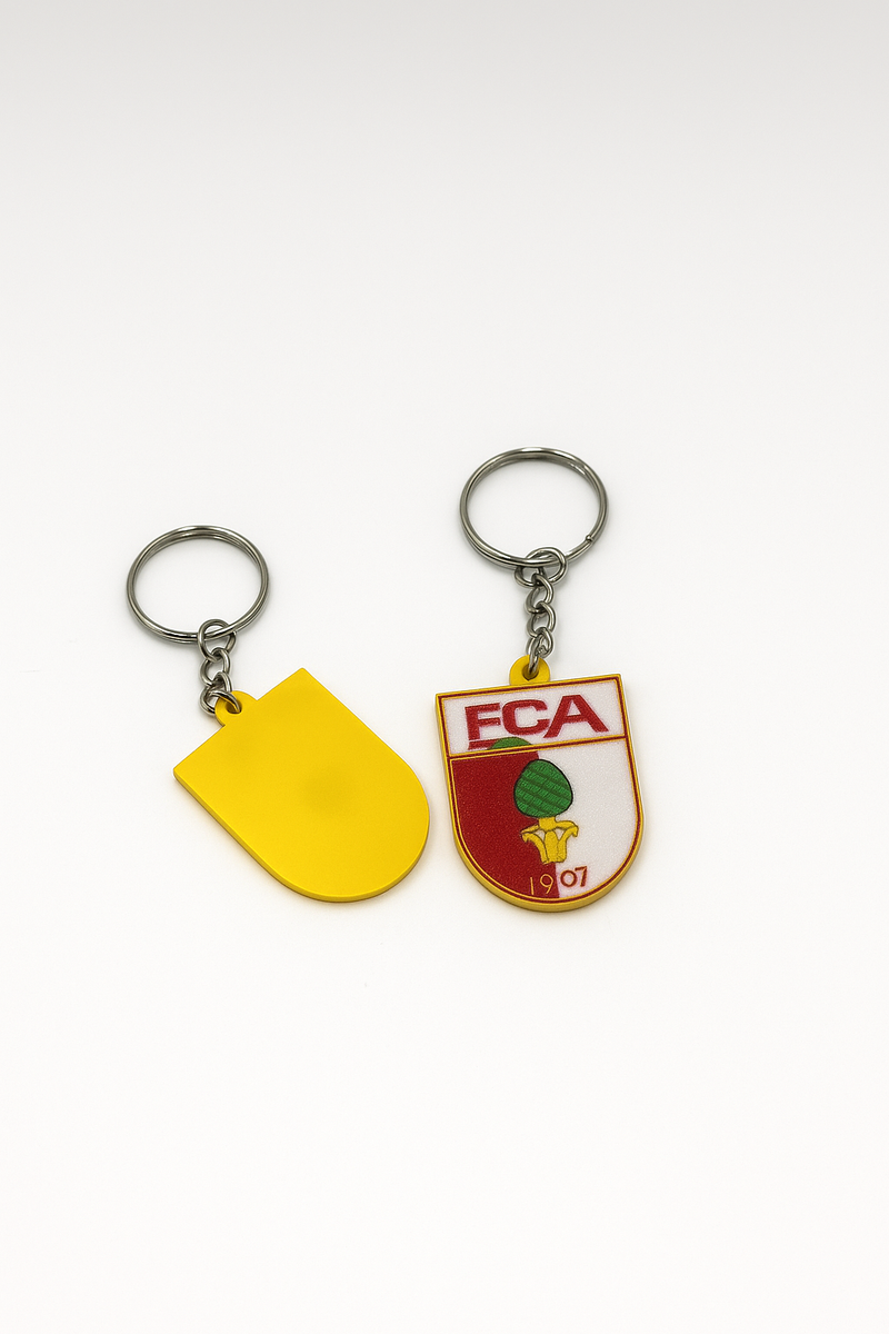 FC Augsburg Schlüsselanhänger neben Autoschlüssel auf weißem Tisch