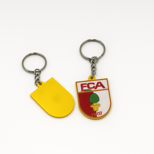 FC Augsburg Schlüsselanhänger neben Autoschlüssel auf weißem Tisch